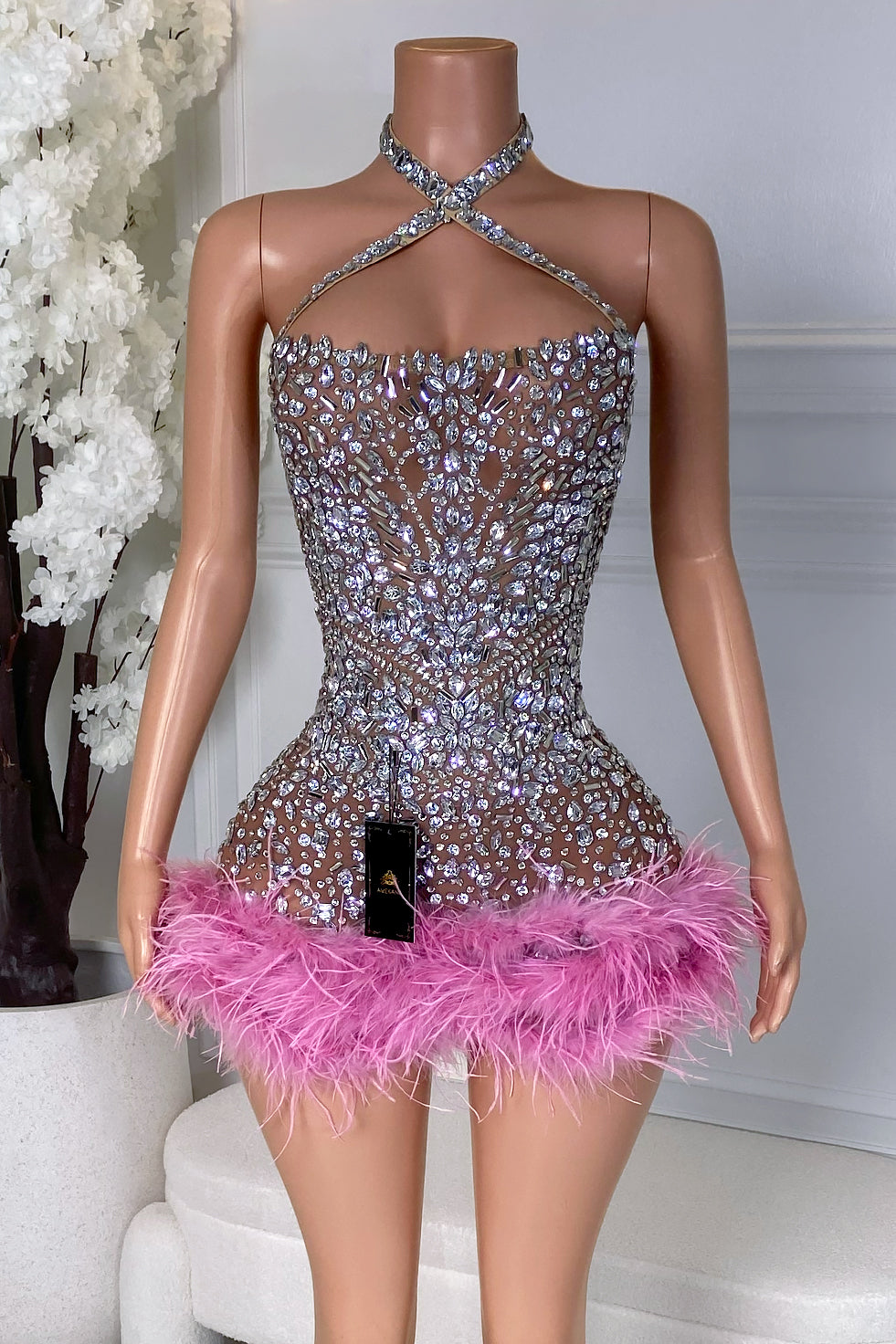 Front view of the limoris Pink Feather Mini Dress featuring silver crystal embellishments, a crisscross halter neckline, and pink feather hem.