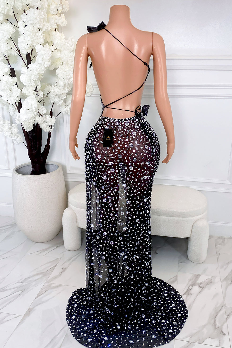 Back view of black rhinestone cutout maxi dress with open back lace-up tie and sheer skirt