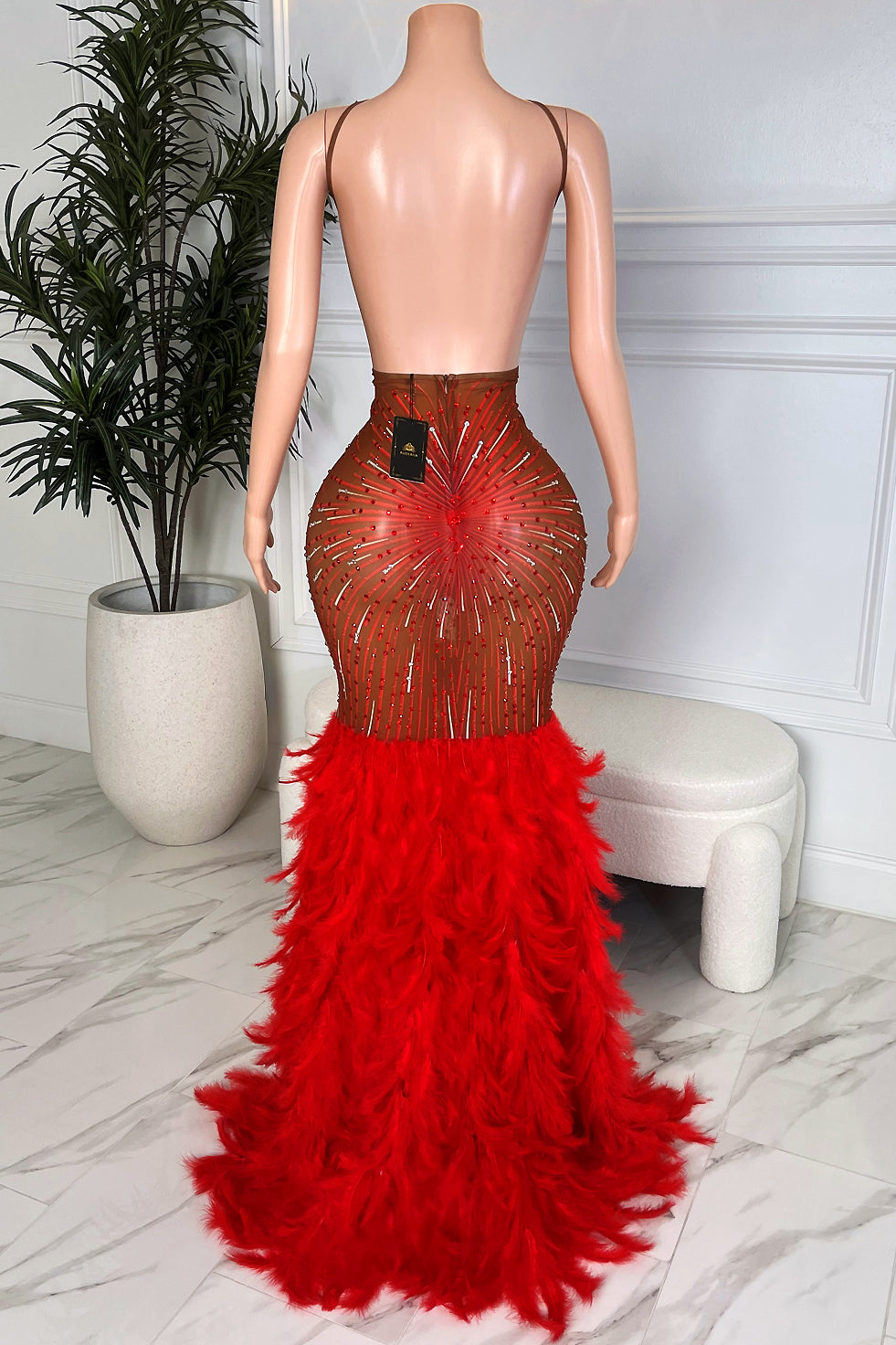 Back view brown nude mesh rhinestone gown with red feather mermaid train and halter strap detail