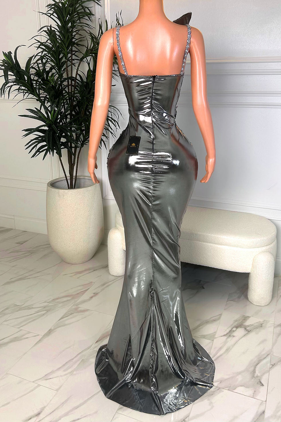 Front view of silver metallic one-shoulder mermaid gown with draped bodice, rhinestone trim, and waist cut-out detailing