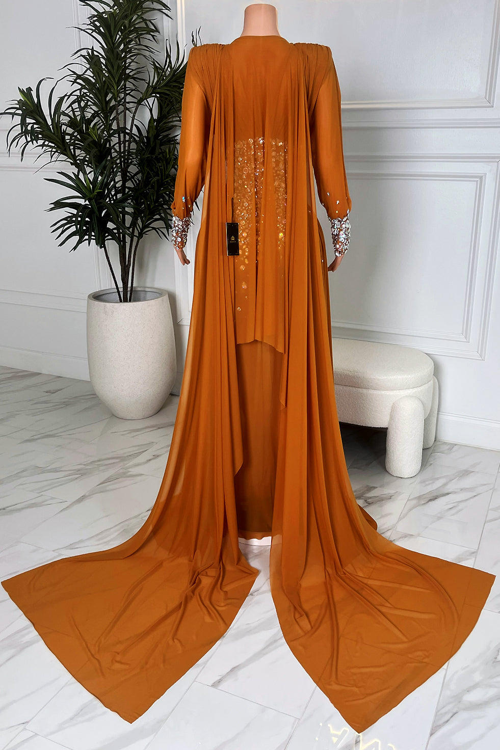 Back view of cognac brown rhinestone maxi gown with flowing chiffon train by Amekana