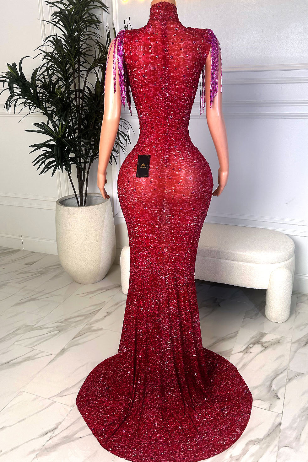 Crimson sequin gown with nude illusion panel, crystal trim detailing, and shoulder fringe accents, front view