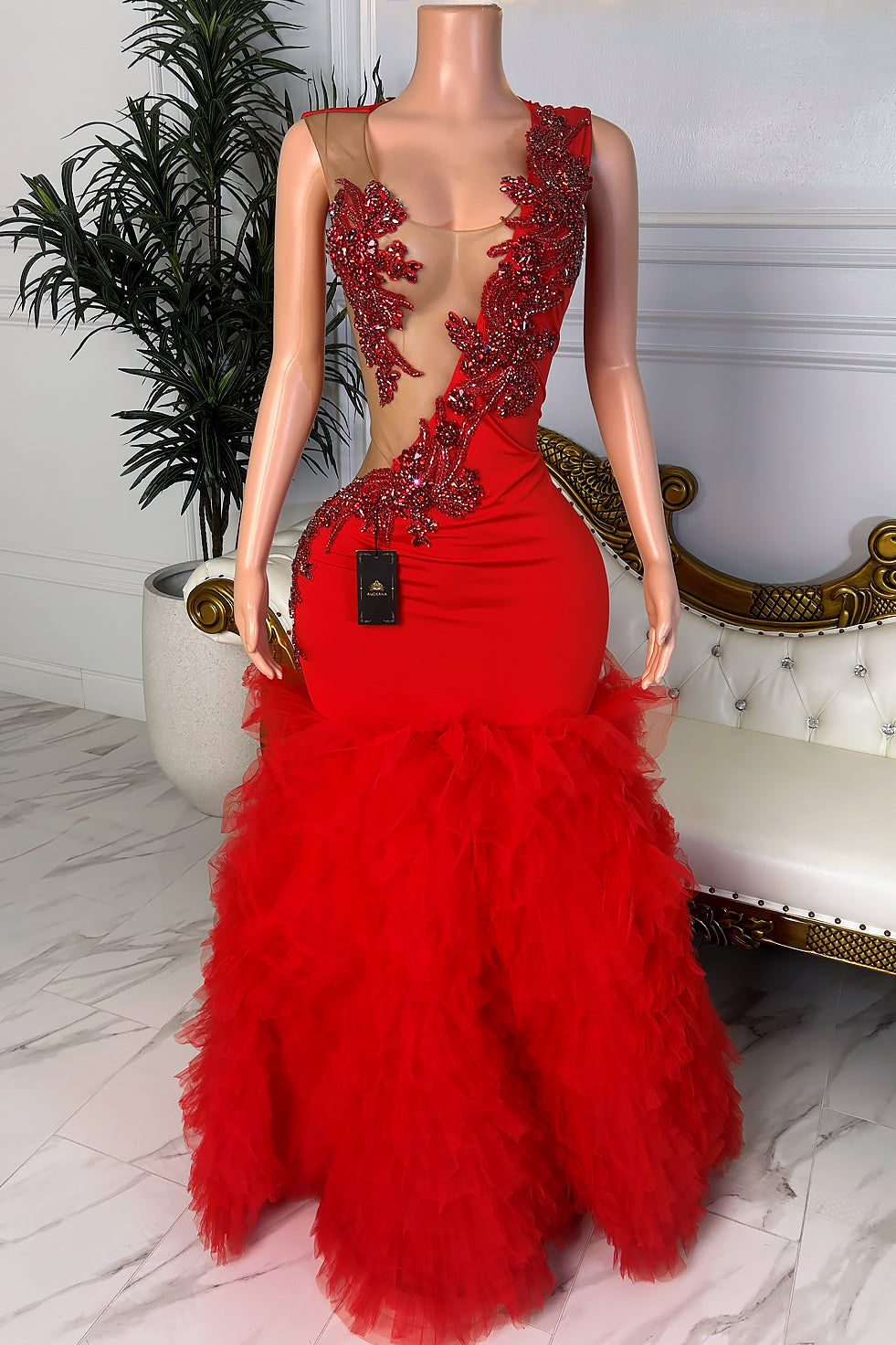 Front view of a red fitted dress with nude illusion mesh, red sequin appliqué details, structured sleeveless bodice, and layered ruffle tulle hem.