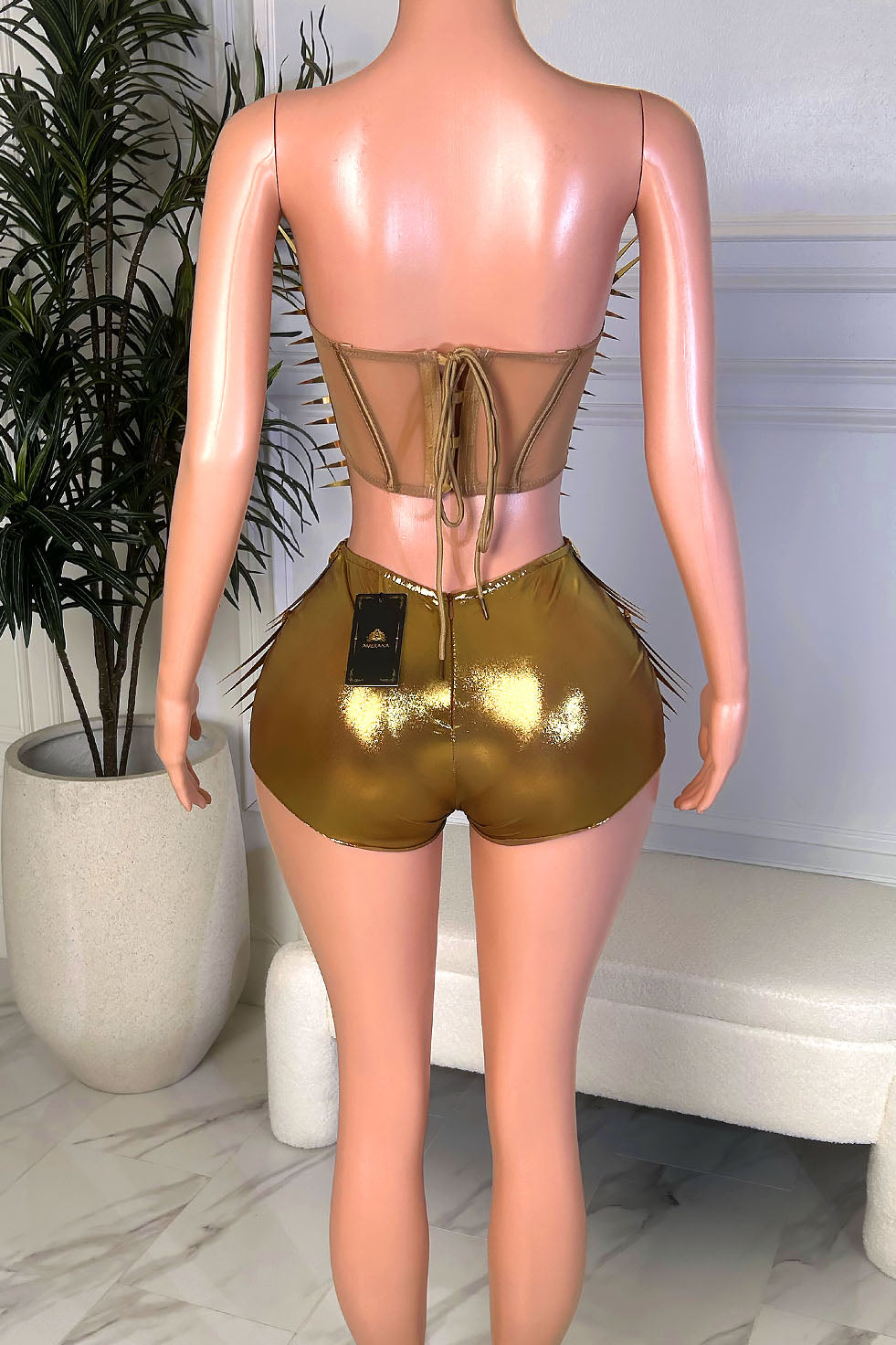 Back view of a gold metallic two-piece set with a lace-up sheer back top and fitted high-waisted shorts