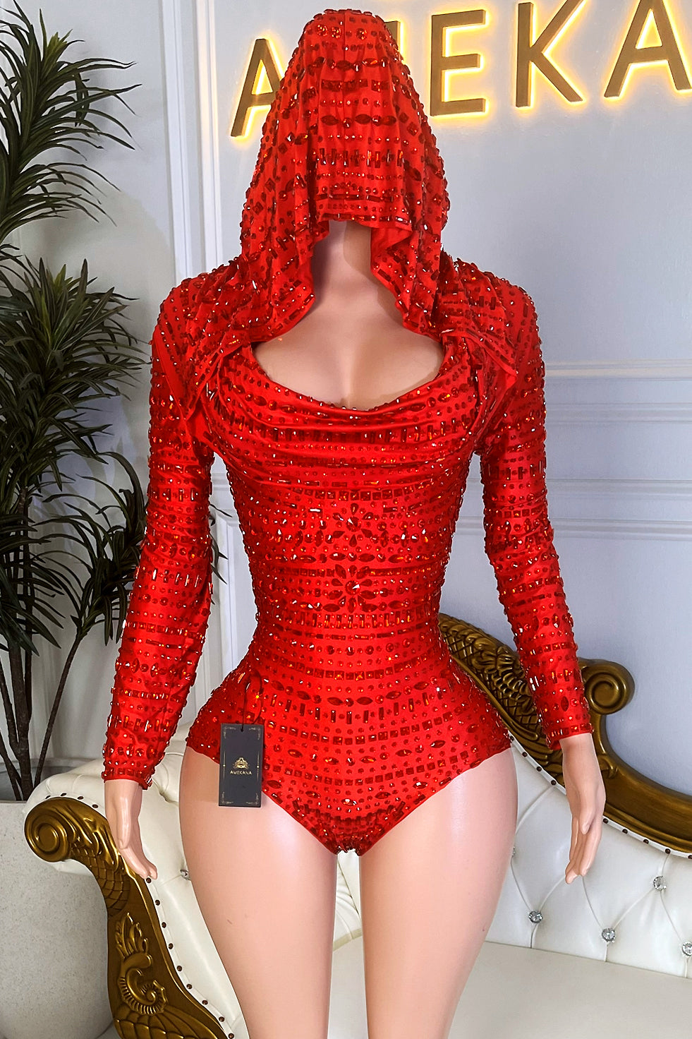 Red rhinestone hooded bodysuit with cowl neckline, long sleeves, and all-over sparkle for party wear