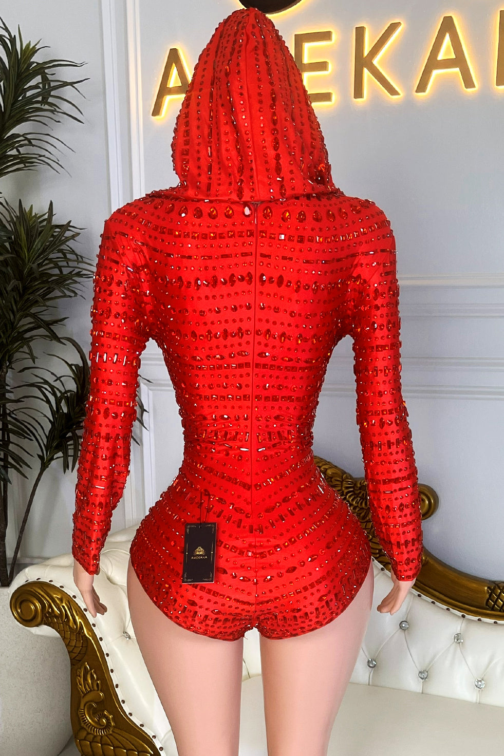 Red rhinestone hooded bodysuit with cowl neckline, long sleeves, and all-over sparkle for party wear
