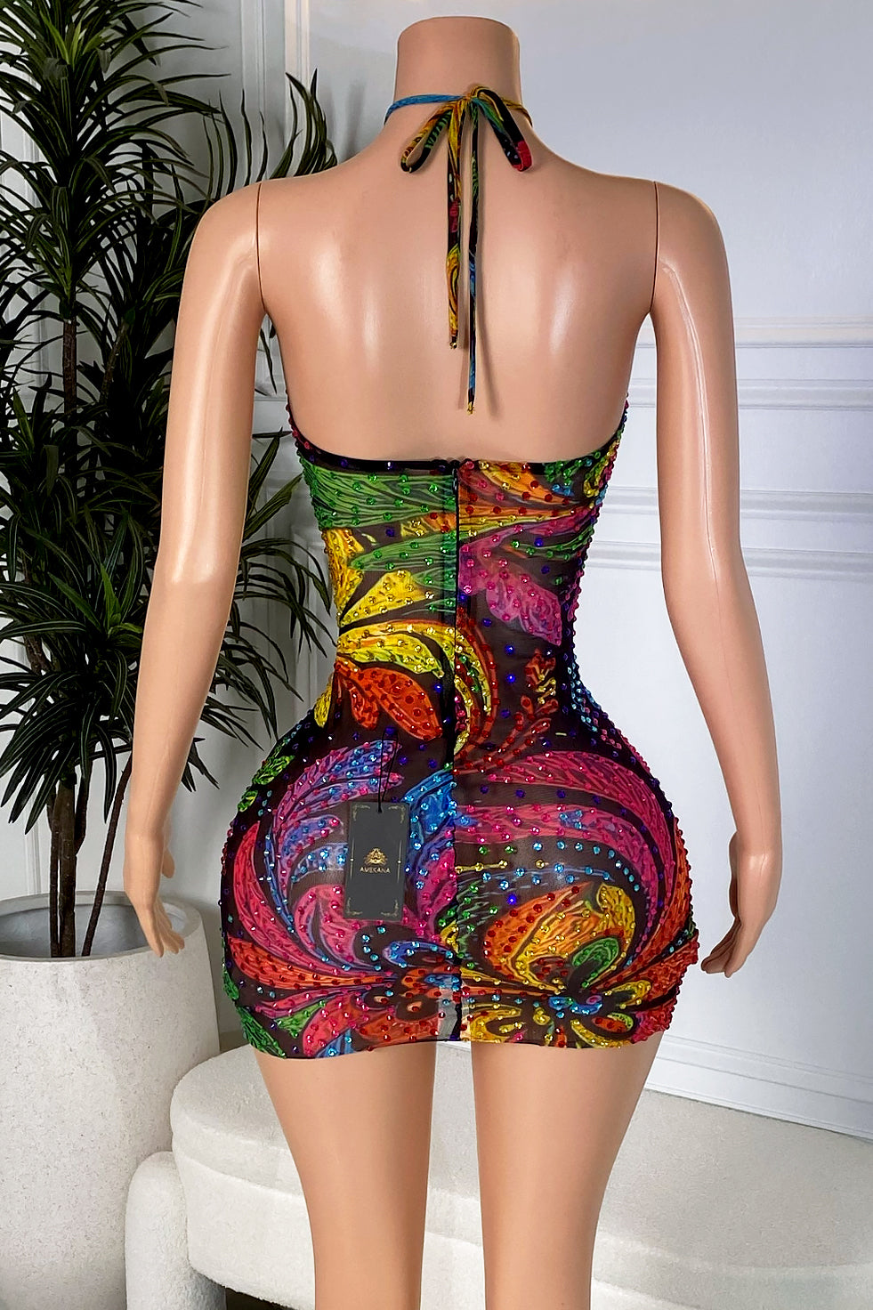 Back view of a multicolor crystal halter mini dress with an adjustable neck tie, low open back, center zipper, and fitted silhouette.