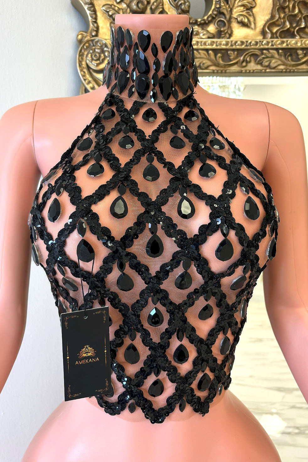 Front view of black rhinestone lattice halter crop top with high gem choker neckline on mannequin.