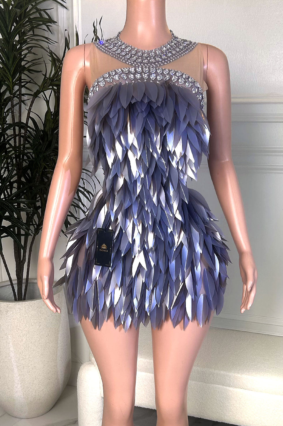 Front view of a lavender and silver embellished mini dress with high crystal neckline, illusion mesh bodice, and layered petal-style detailing