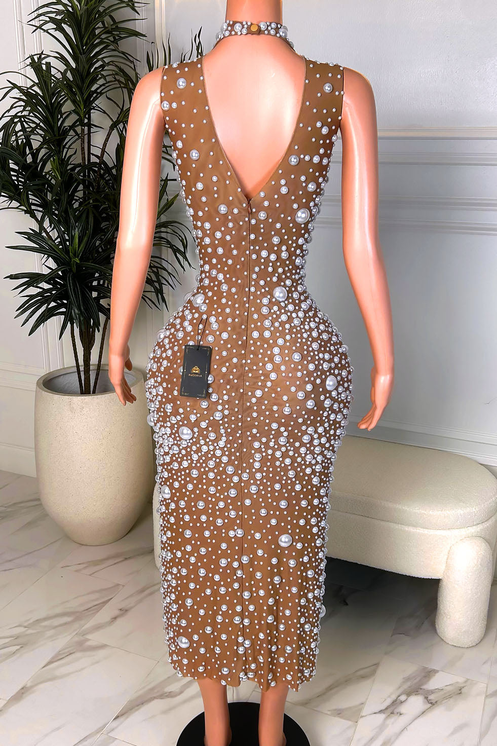 Back view of a nude illusion pearl embellished midi dress with a deep V-back, sleeveless cut, and back zipper closure