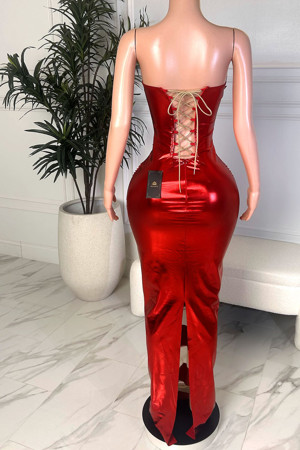 Back view of Scarlet Flame Gown, a metallic red lace-up back maxi dress with a fitted silhouette and back slit