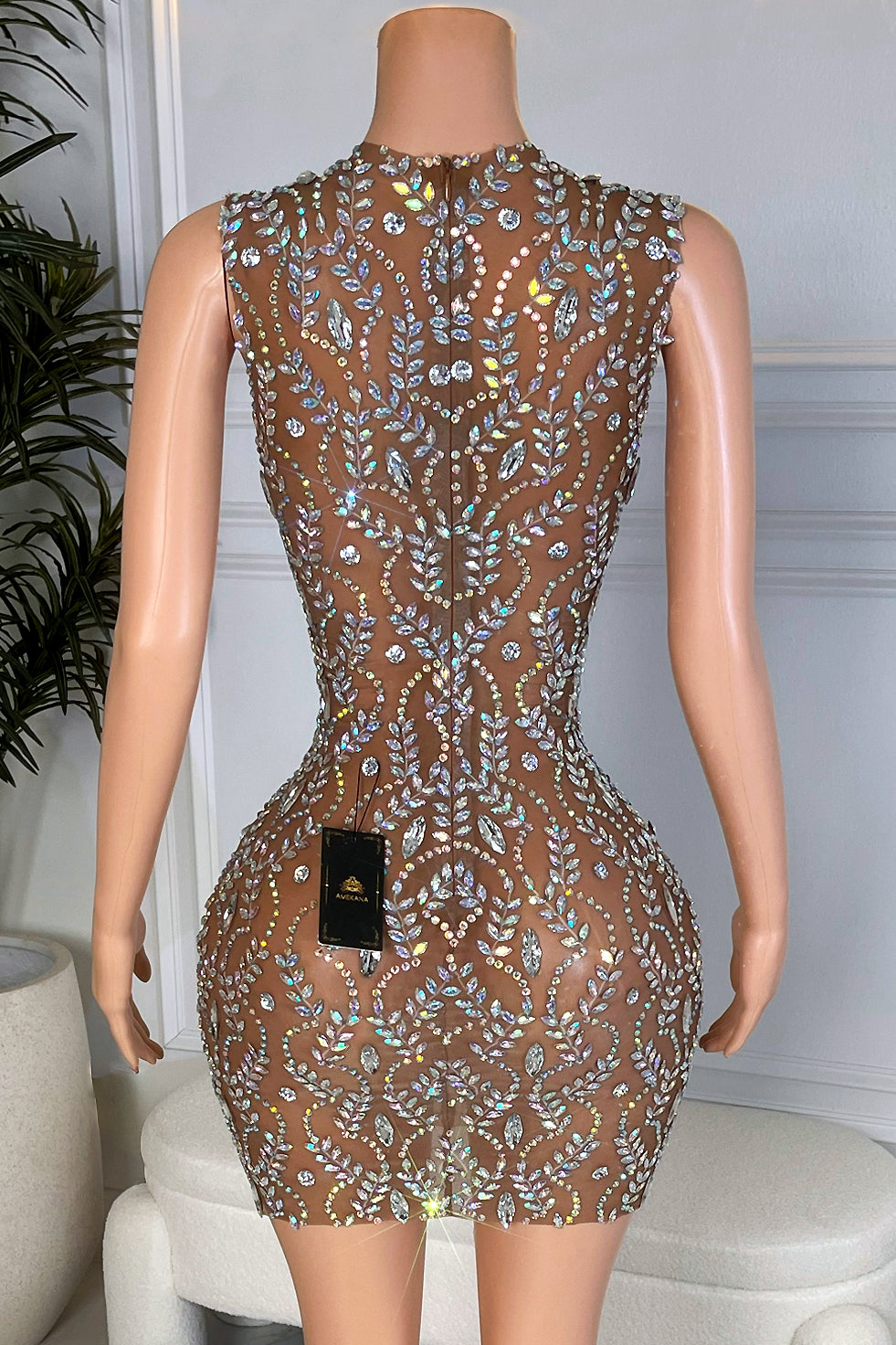 Close front view of the nude mesh mini dress showing the detailed silver rhinestone leaf and vine pattern and curve hugging fit.
