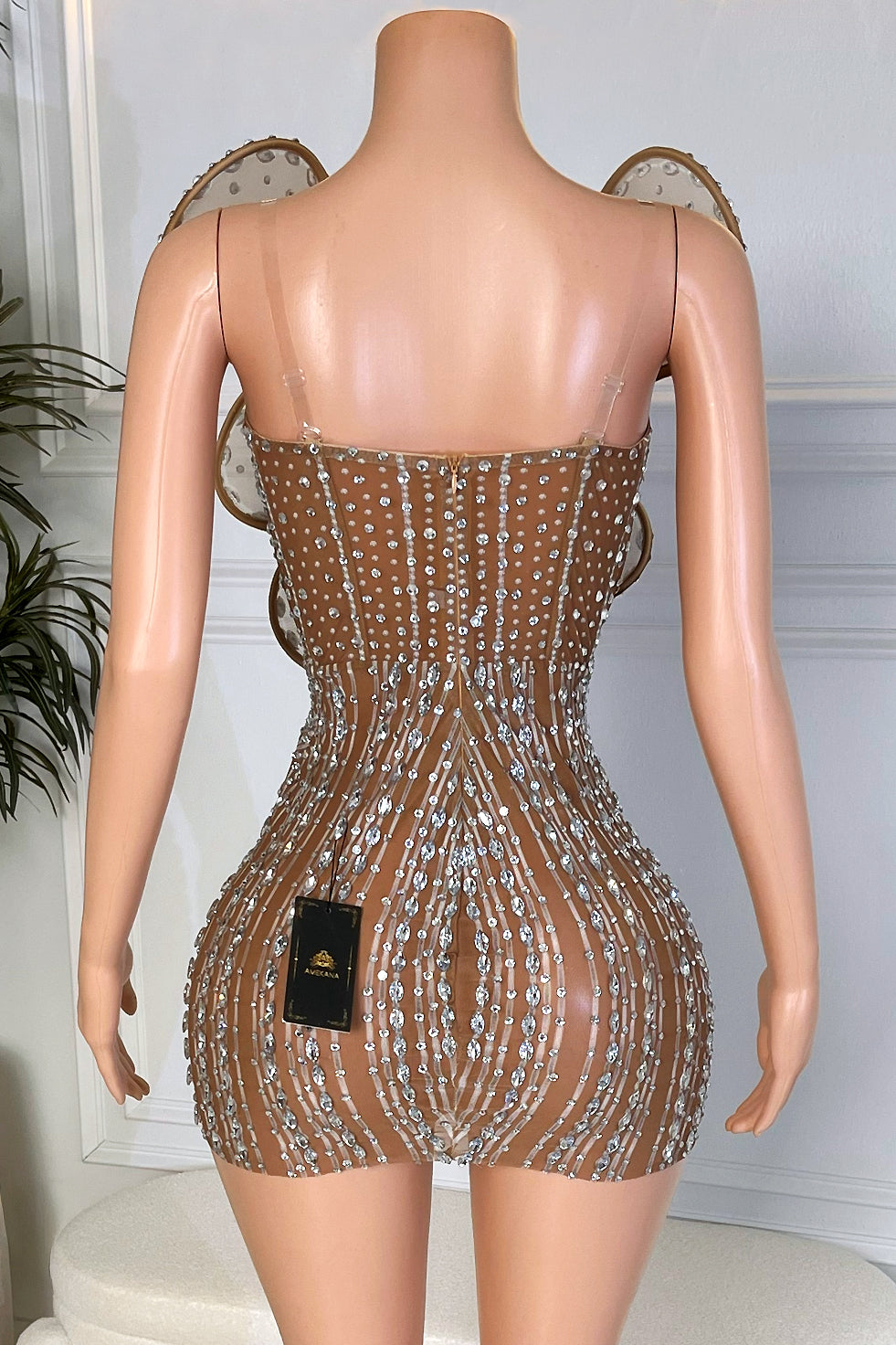 Back view of nude mesh rhinestone mini dress with vertical crystal stripe detailing and clear straps