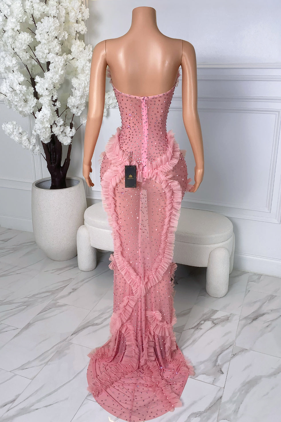 Back view of pink rhinestone dress with cascading ruffle accents and zipper closure
