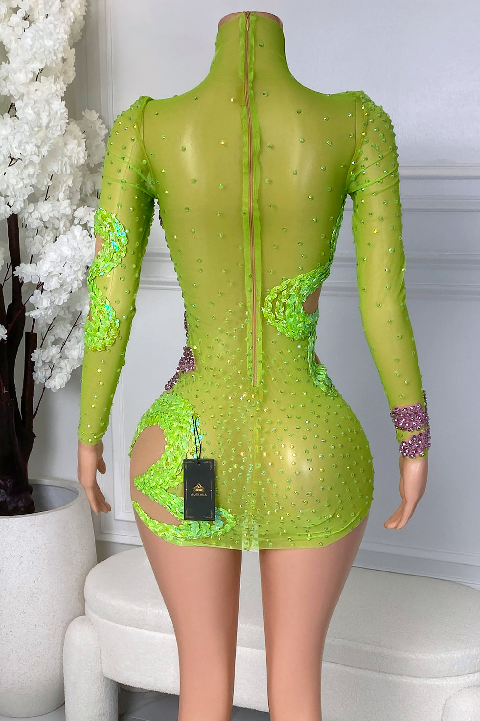Back view of the Zavina Lucky Charm Mini Dress showing the high neckline, long sleeves, back zipper closure, lime green mesh, and rhinestone embellishments.